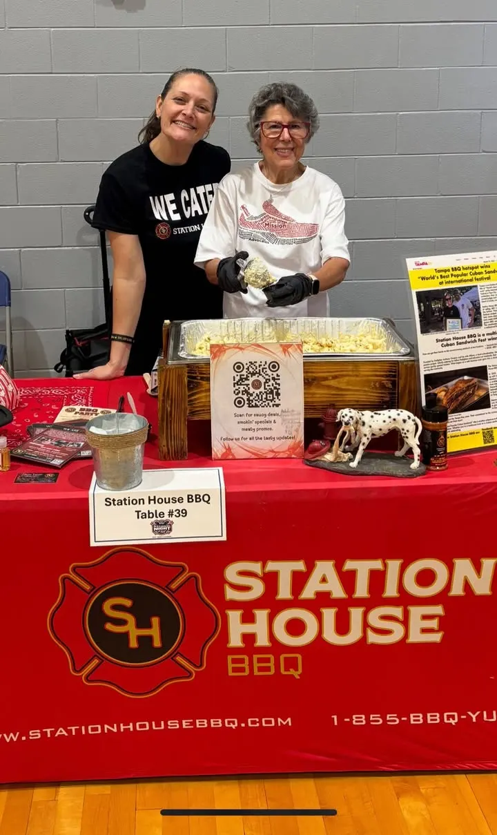 Station House BBQ team serving smoked mac and cheese at a branded booth